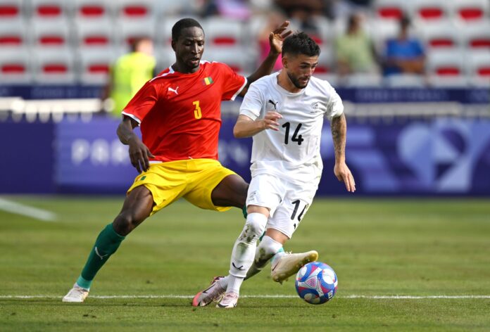 Jay Herdman of New Zealand faces Bangaly Cisse of Guinea in an Olympic football competition.